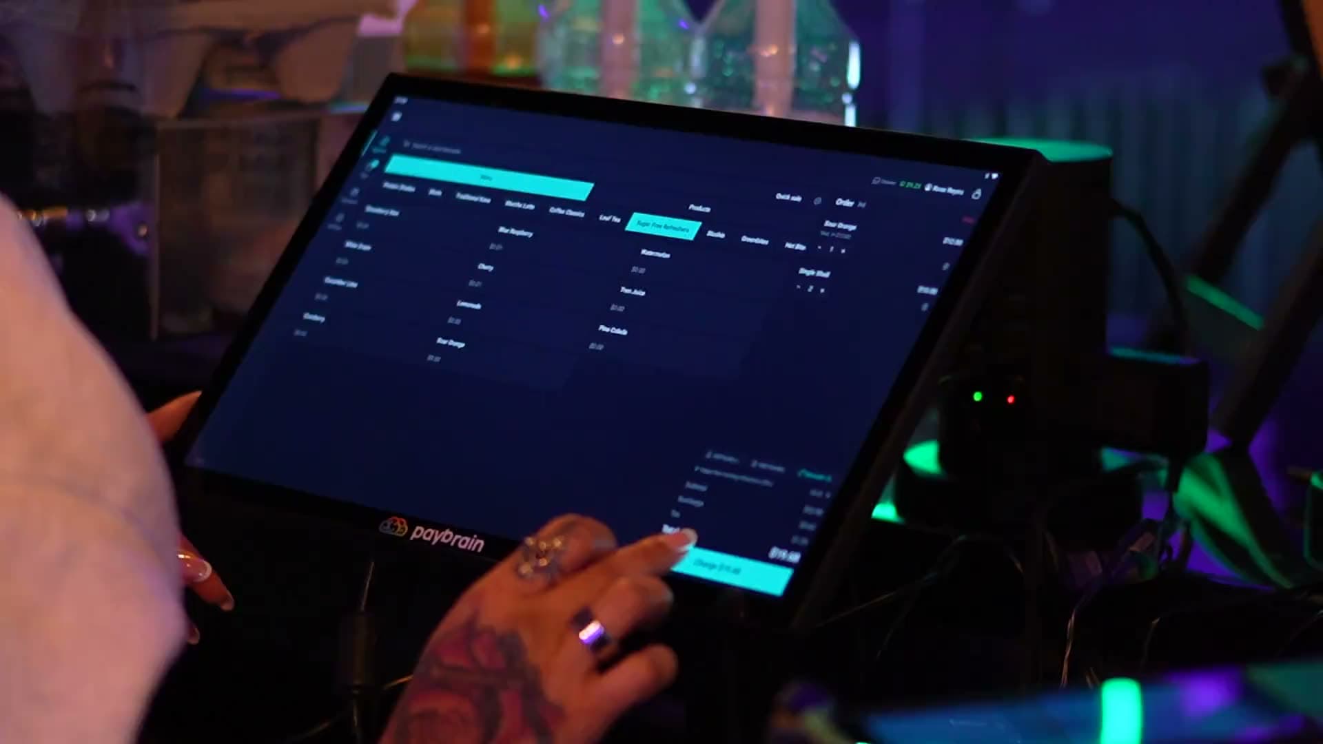 A bartender ringing up an order on the Paybrain register